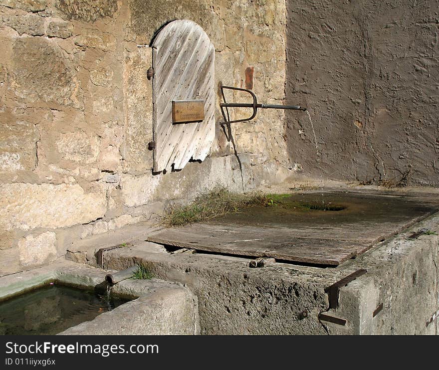 Ancient artesian spring, coming out of an old pipe in the thick walls of this venerable fortress city, in central Germany, in late October. Ancient artesian spring, coming out of an old pipe in the thick walls of this venerable fortress city, in central Germany, in late October.