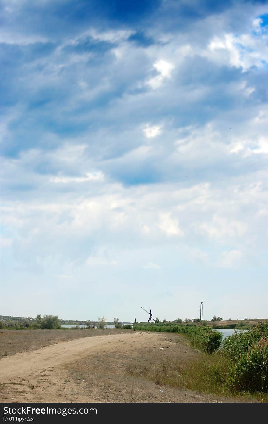 Rural road on background year blue sky and clouds