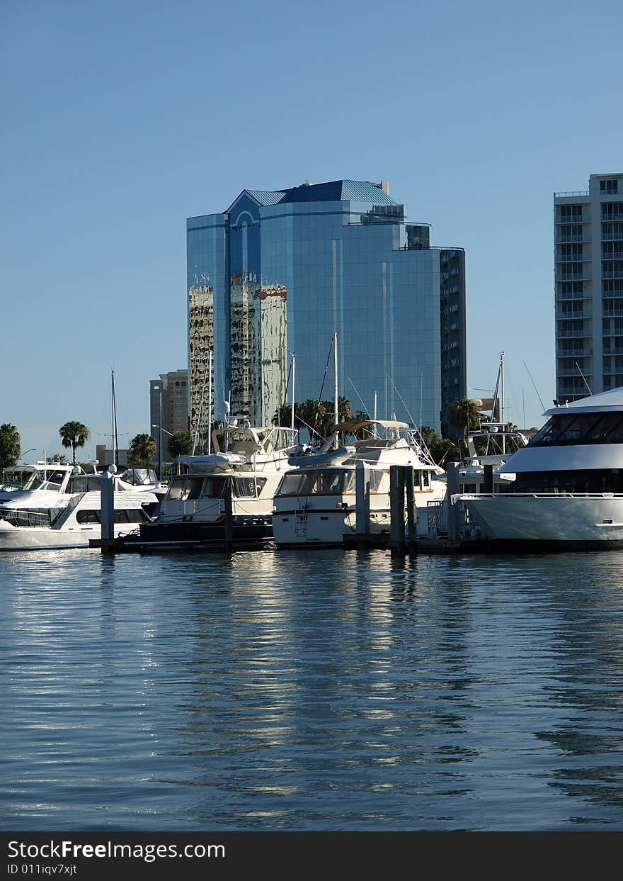 Luxury Glass Hotel with Yachts in Harbor blue sky and water