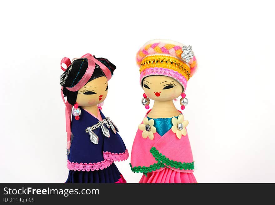 Two Chinese dolls with ethnologic clothes and headgear on white background. Two Chinese dolls with ethnologic clothes and headgear on white background.