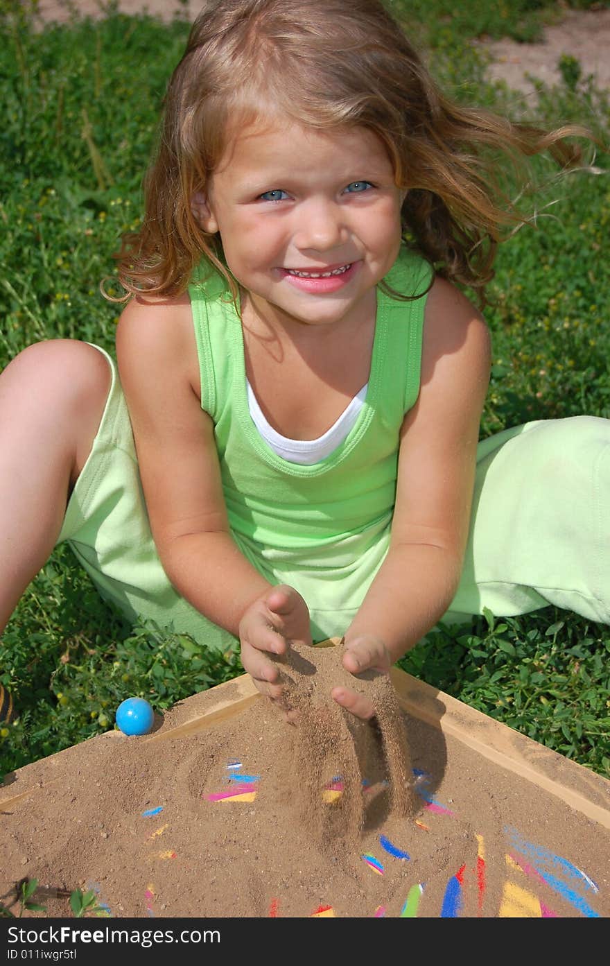 Young Pretty Girl Playing With Sand