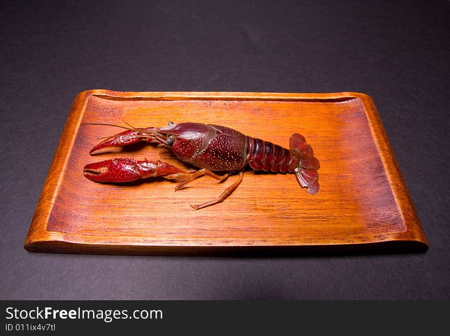 Seafood crawdads with covering in a wooden plate.