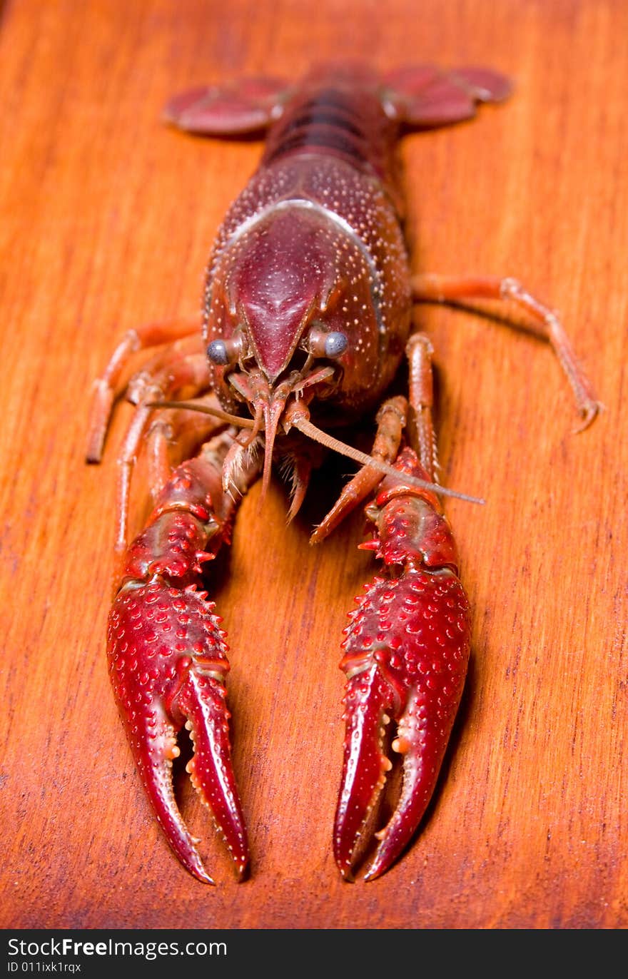 Seafood crawdads with shells in a wooden plate.