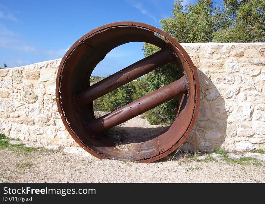 Juxtaposition of a modern stone wall built around a rusty old cylindrical mining object, in the Innes National Park, Yorke Peninsula, South Australia. Juxtaposition of a modern stone wall built around a rusty old cylindrical mining object, in the Innes National Park, Yorke Peninsula, South Australia.