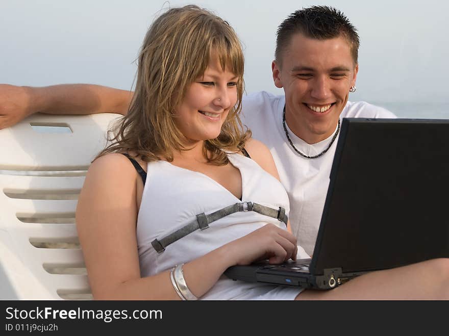 The man and the woman have a rest on coast of ocean. The man and the woman have a rest on coast of ocean