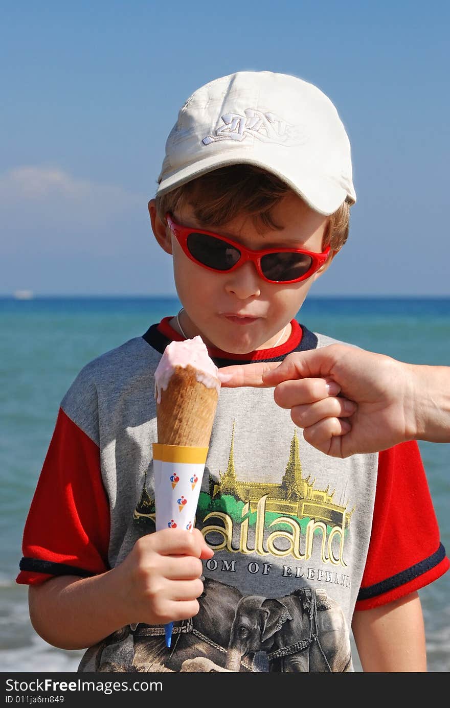 On seacoast the boy eats ice cream