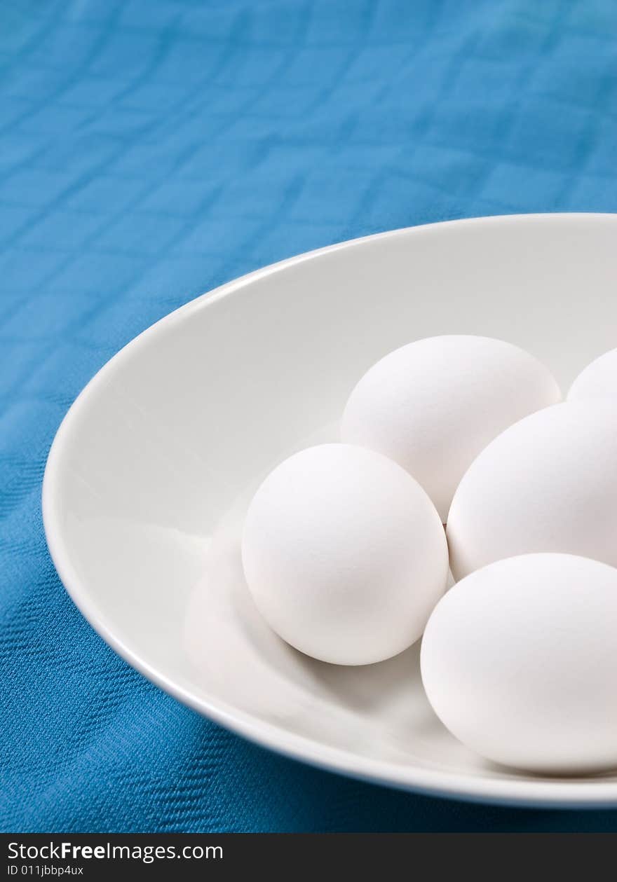 Eggs in white bowl with a colorful background. Eggs in white bowl with a colorful background