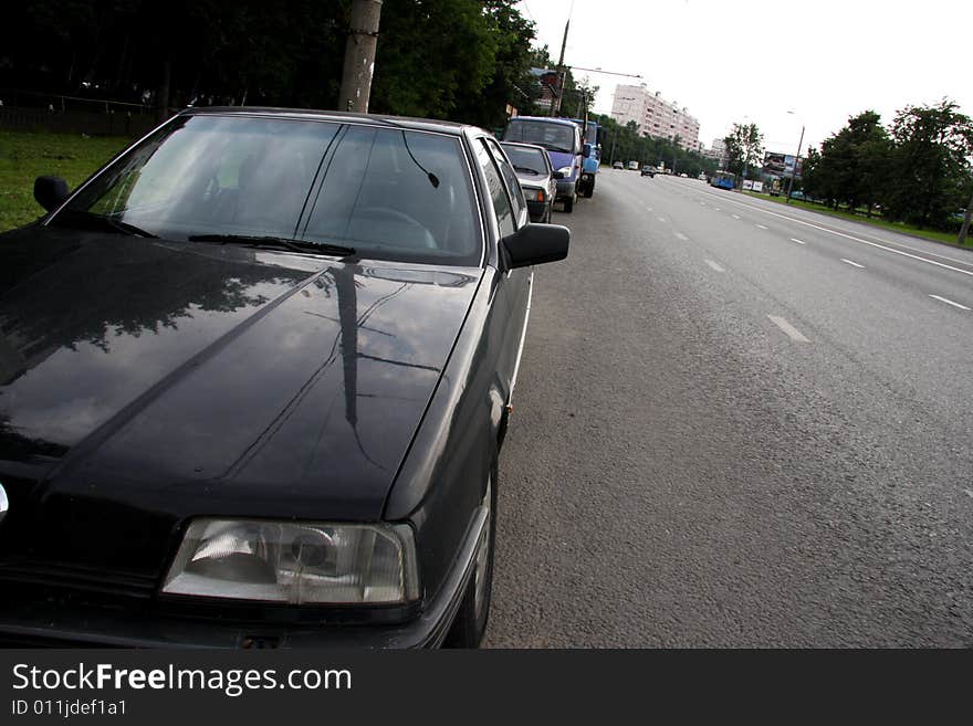 Black car next to the road on the sidelines. Black car next to the road on the sidelines