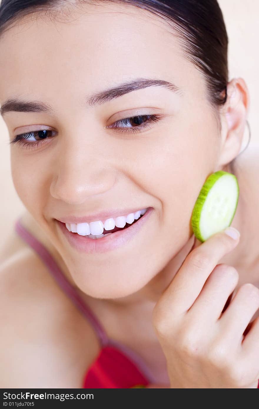 Woman holding cucumber close her face