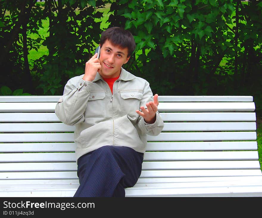 Photo of the young man on a shop, speaking by phone. Photo of the young man on a shop, speaking by phone.