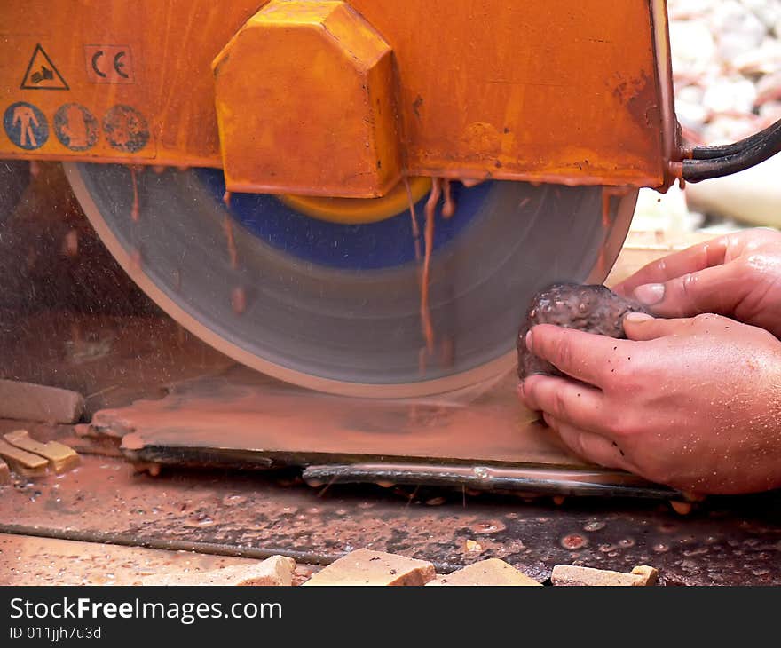 Close up of the circular saw and man's hands at work. Cutting of stones on the circular saw.