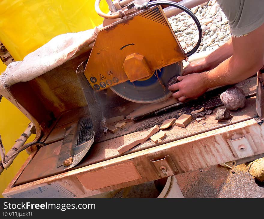 Close up of the circular saw and man's hands at work. Cutting of stones on the circular saw.