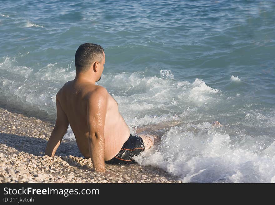 Man Relaxing In The Water On The Beach