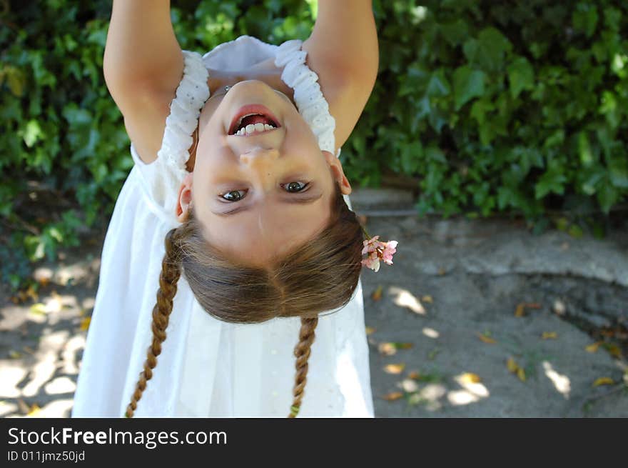 A girl with pigtails hangs from a tree. A girl with pigtails hangs from a tree