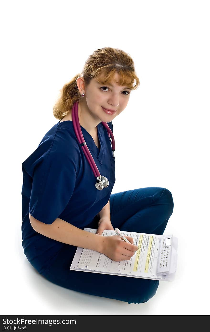 Young female doctor with stethoscope and writing pad over white background