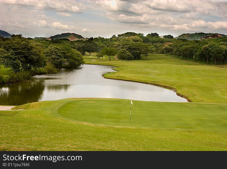 A golf course and lake under stormy skies. A golf course and lake under stormy skies