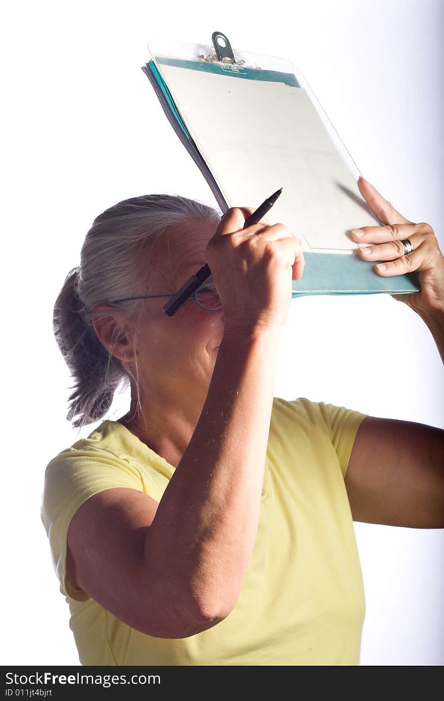 Senior woman marking clipboard,wearing glasses. Senior woman marking clipboard,wearing glasses