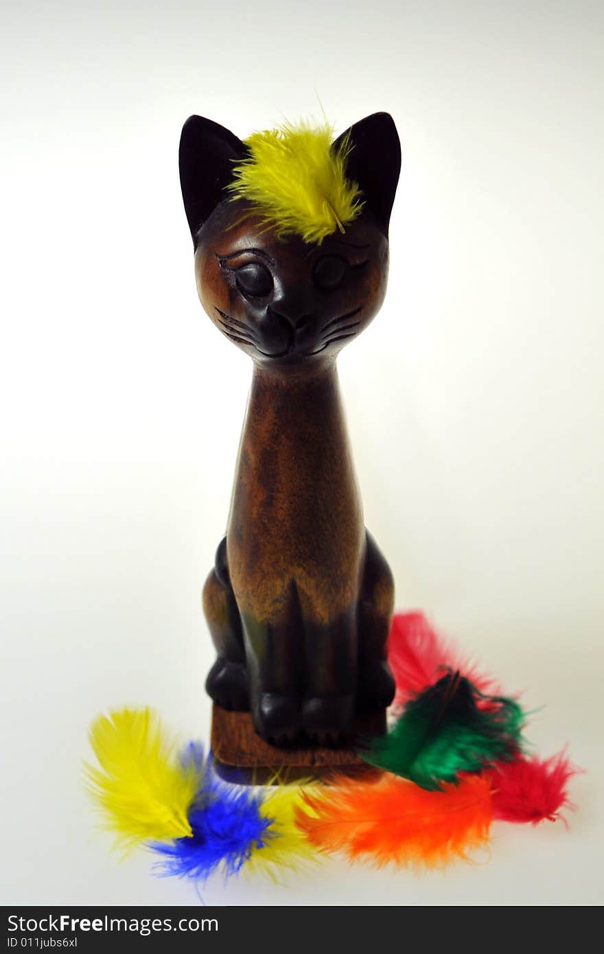 Wooden Cat and Colourful Feathers on white background