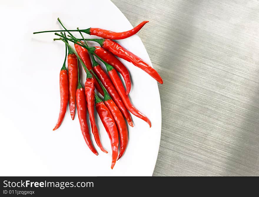 Hot Red Cayenne Peppers on White Plate on Stainles