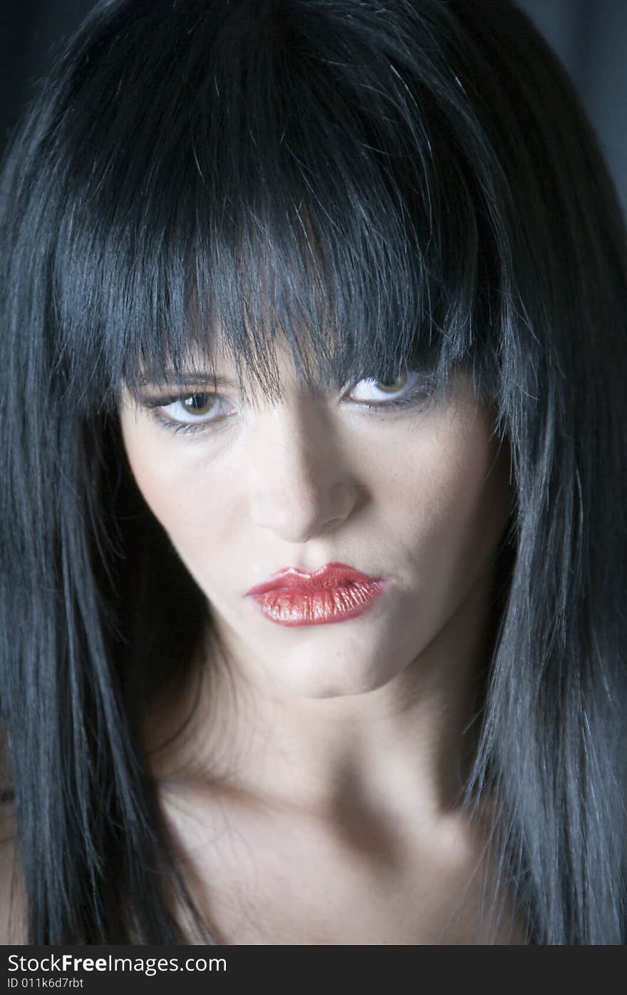 A close up of the face of a young woman with green eyes and red lipstick. A close up of the face of a young woman with green eyes and red lipstick.