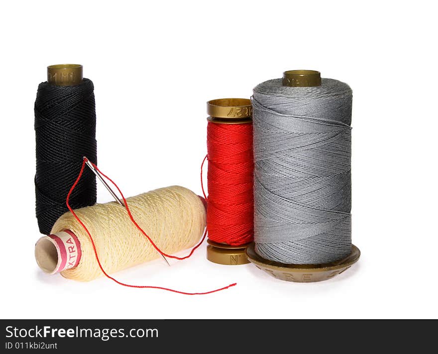 Reels of thread and needle on white background