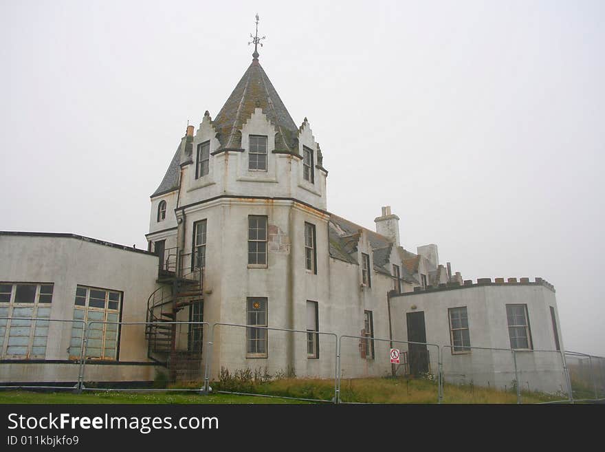 An old hotel abandoned and fenced off.