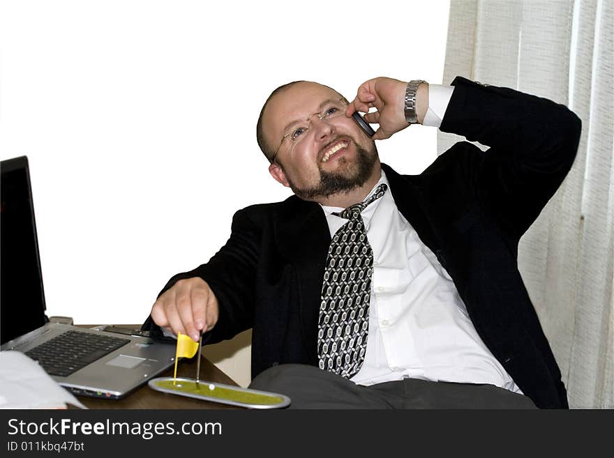 Smiling businessman in the office talking over the phone. Smiling businessman in the office talking over the phone