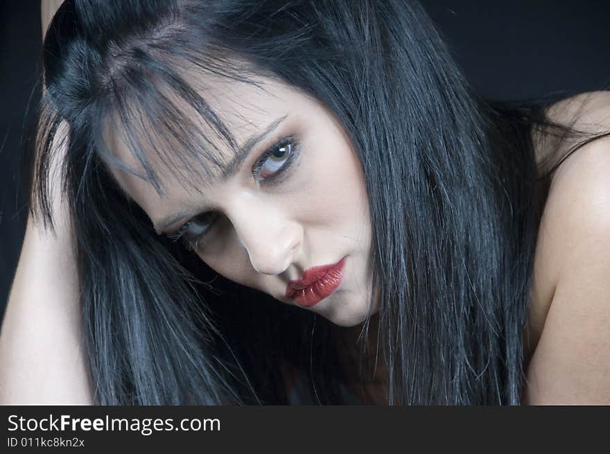 Head and shoulders landscape of a young lady with black hair and red lipstick looking serious. Head and shoulders landscape of a young lady with black hair and red lipstick looking serious.