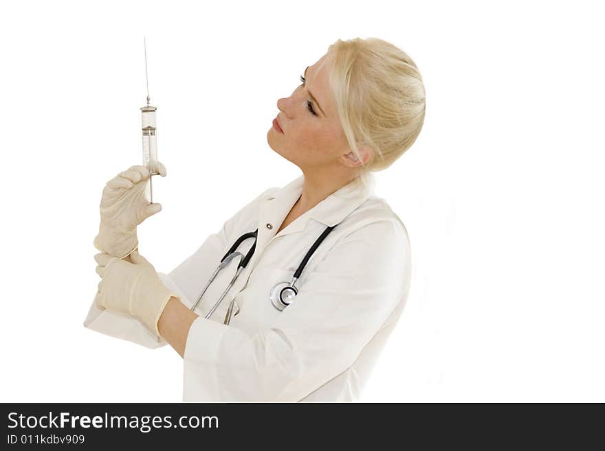 A young female doctor/nurse with gloves looks at syringe  isolated on white background. A young female doctor/nurse with gloves looks at syringe  isolated on white background