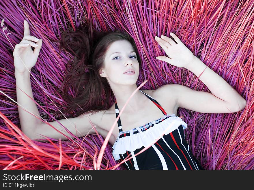 Beauty young woman lying in color grass. Beauty young woman lying in color grass