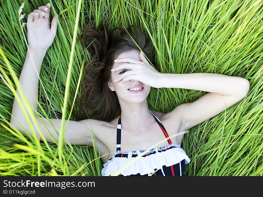 Beauty young woman lying in green fresh grass. Beauty young woman lying in green fresh grass