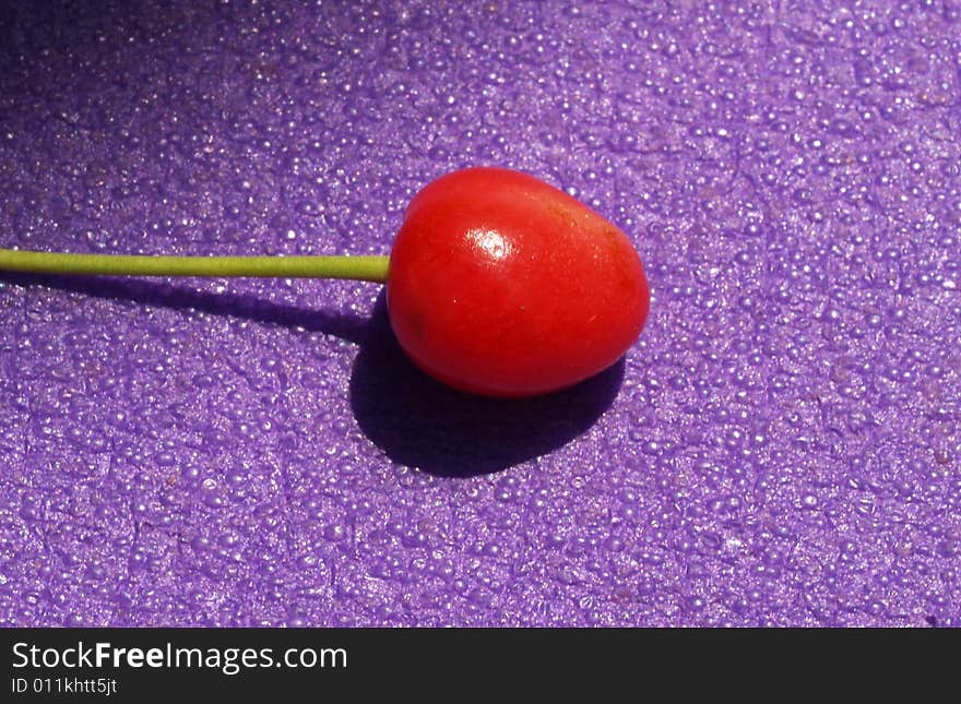 Detail of cherry on violet background