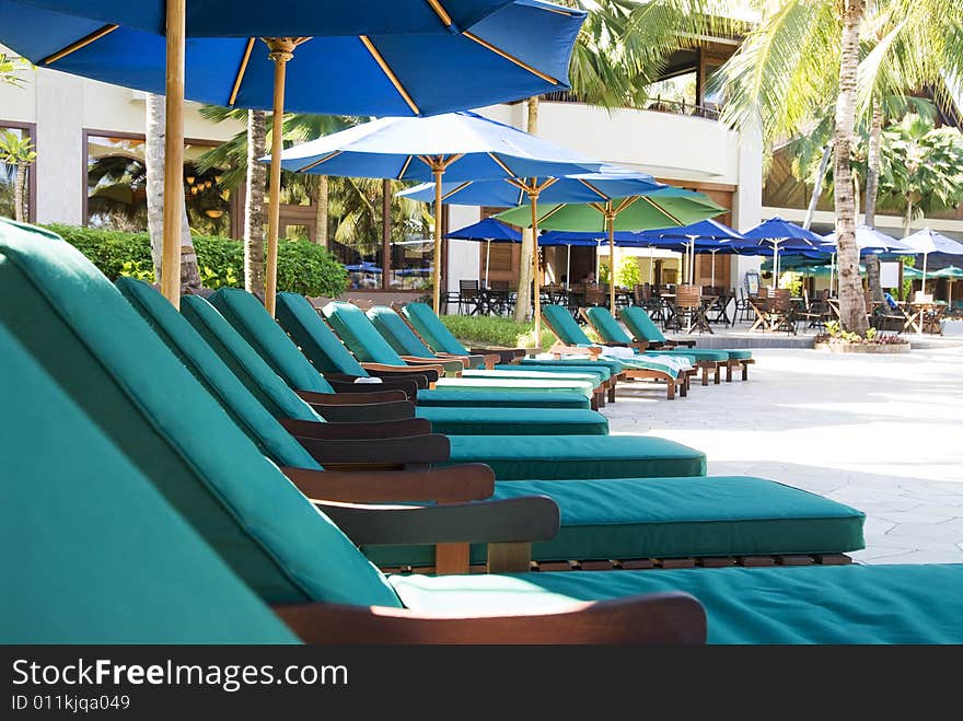 Row of chairs beside swimming pool si at beach resort. Row of chairs beside swimming pool si at beach resort