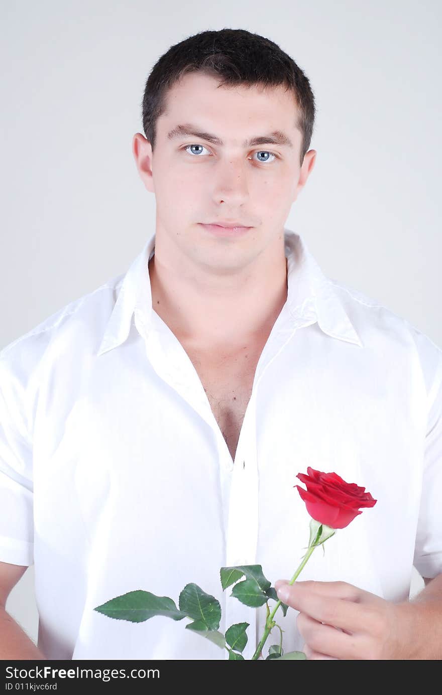 Young athlete man with red rose in hand isolated at white background. Young athlete man with red rose in hand isolated at white background