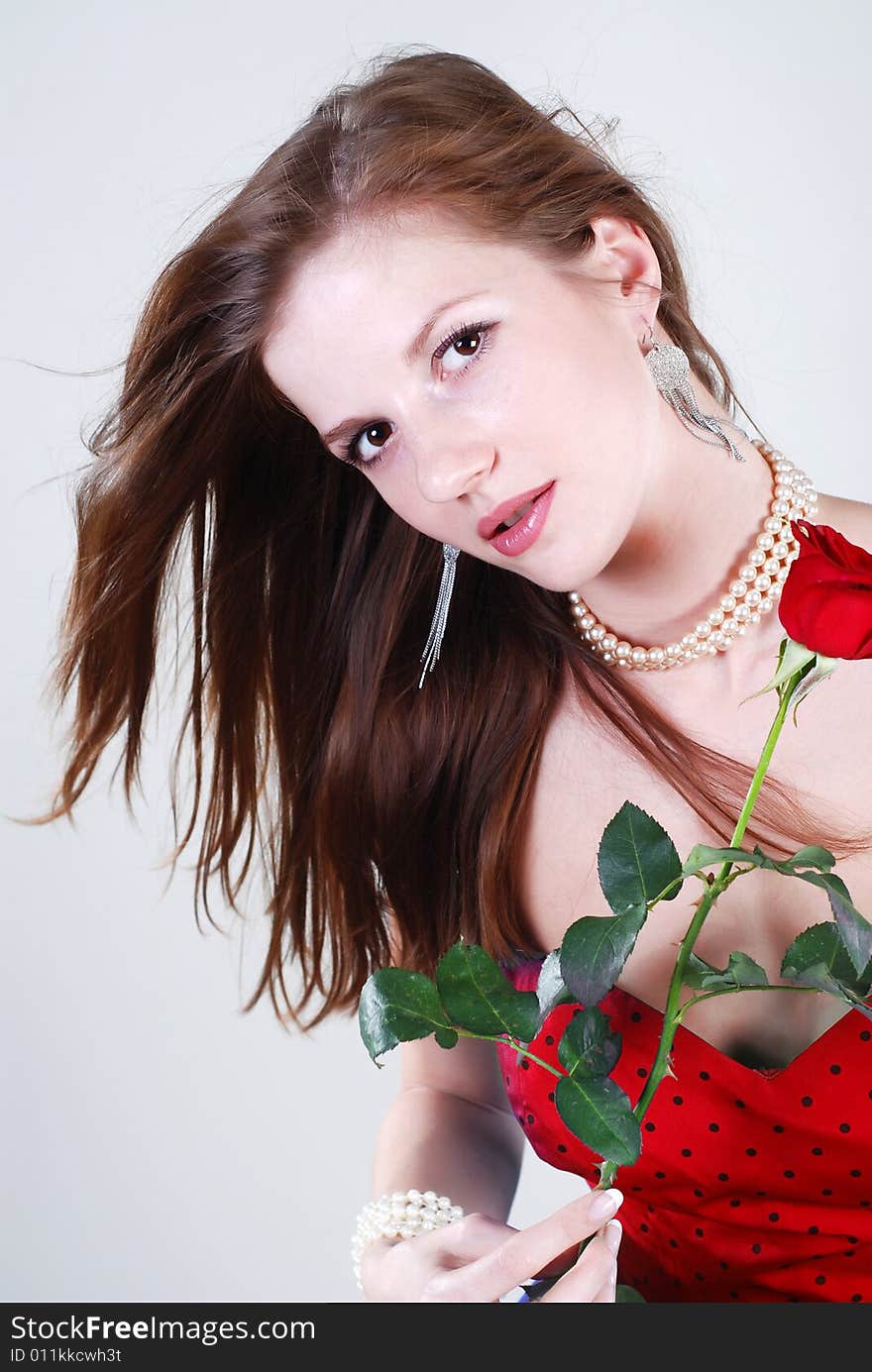 Beauty young woman in red dress with rose at white isolated background