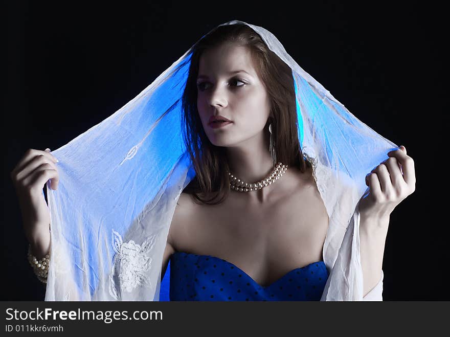 Beauty young woman in blue dress at black background