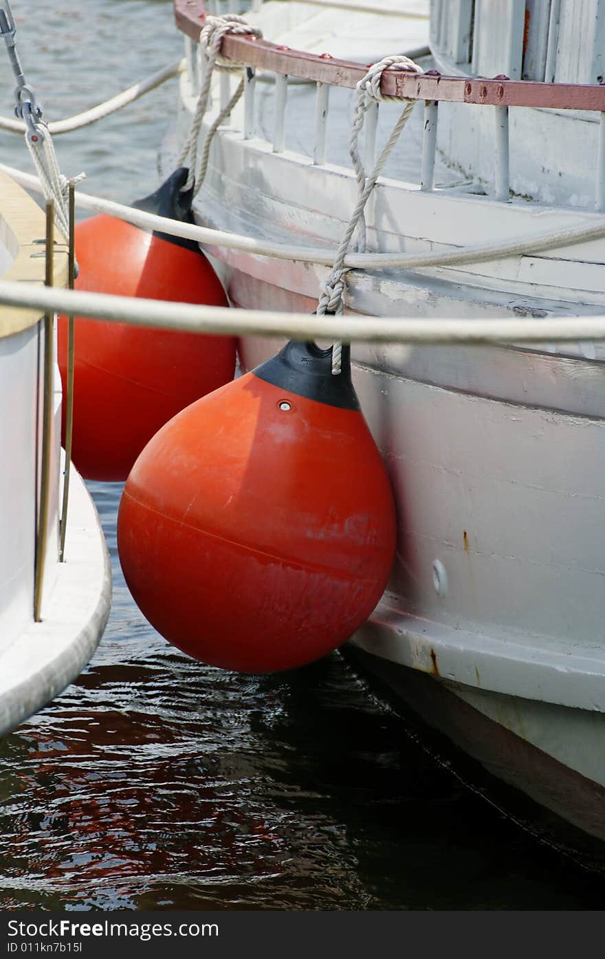 Red boat fenders separating two vessels.