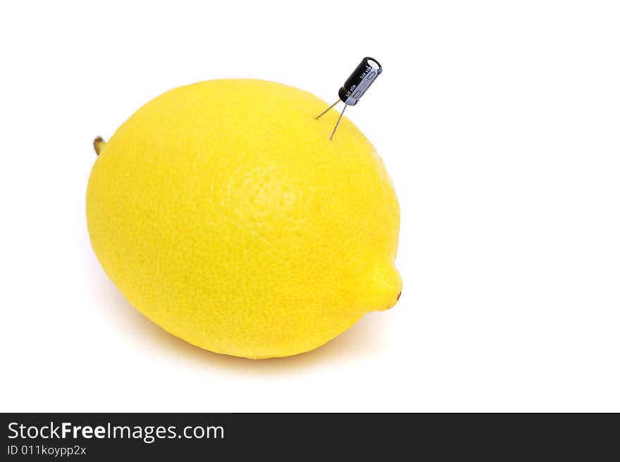 A capacitor plug on fresh lemon over white background. A capacitor plug on fresh lemon over white background.