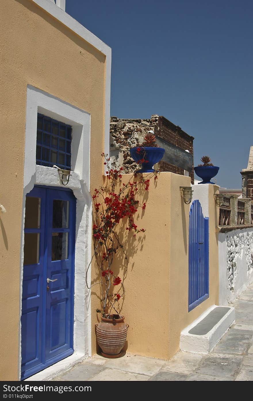 Blue gates and whitewashed walls against the blue sky of Santorini. Blue gates and whitewashed walls against the blue sky of Santorini.