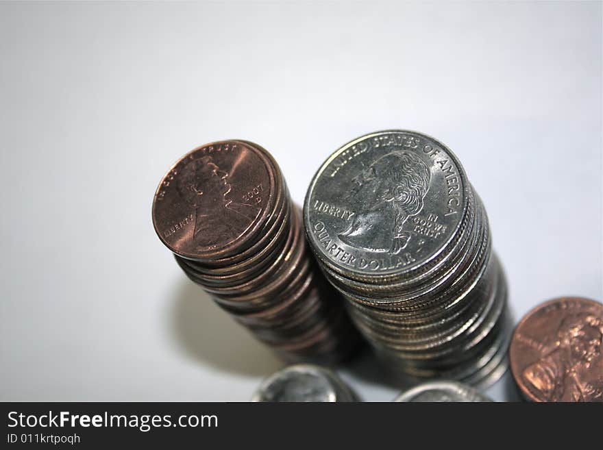 Quarters and pennies, stacked high with white background. Quarters and pennies, stacked high with white background.