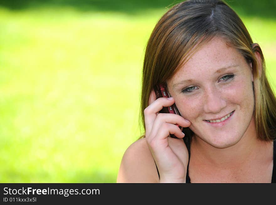 Woman talking on her cell phone in the park. Woman talking on her cell phone in the park