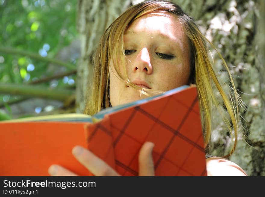 A woman in the park reading a book