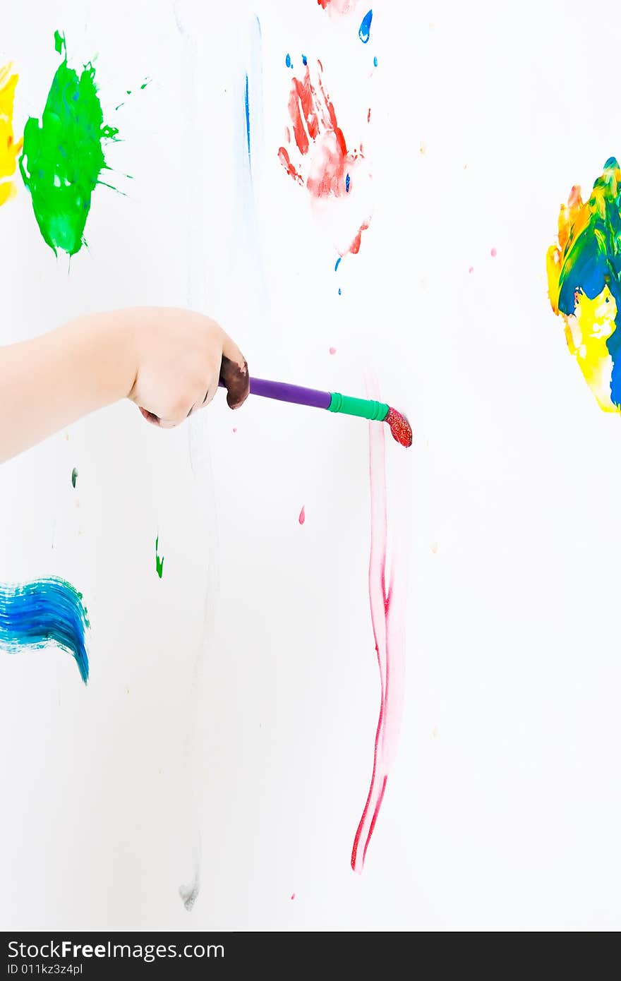 Child painting on the wall with a brush. Child painting on the wall with a brush