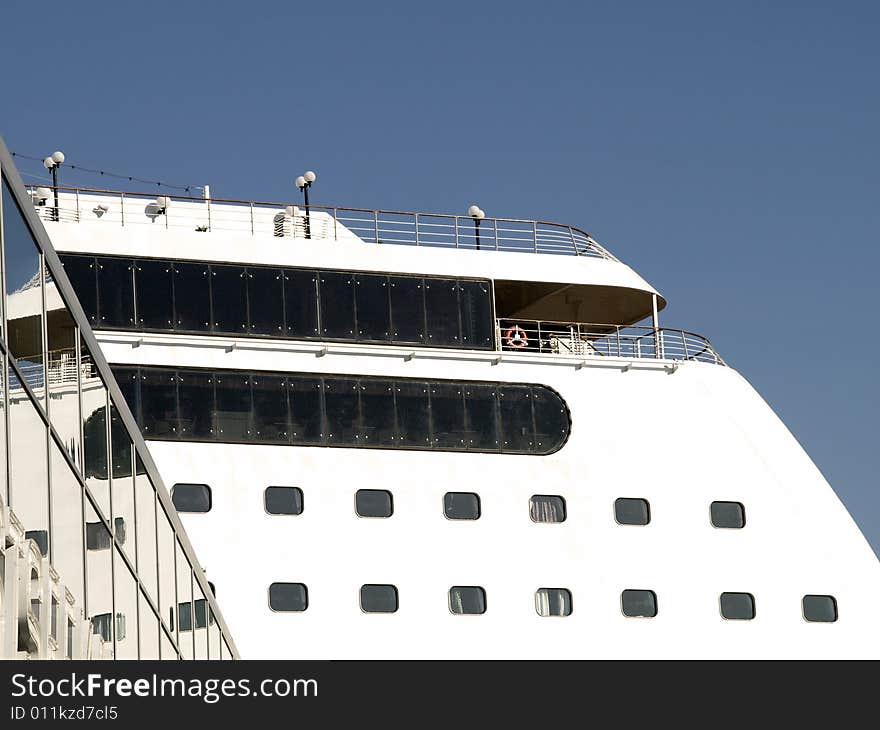 Upper deck of a white cruise liner with cabin windows