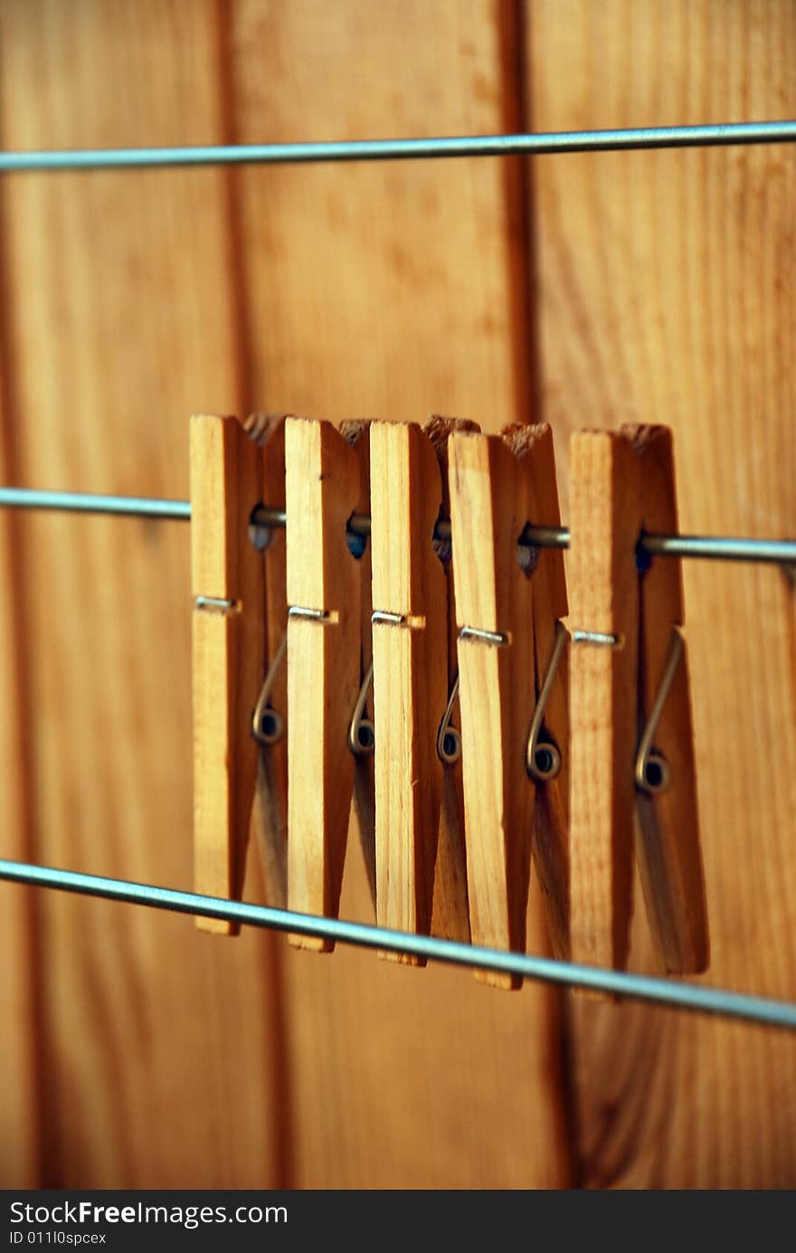 Five clothes-pegs on wire