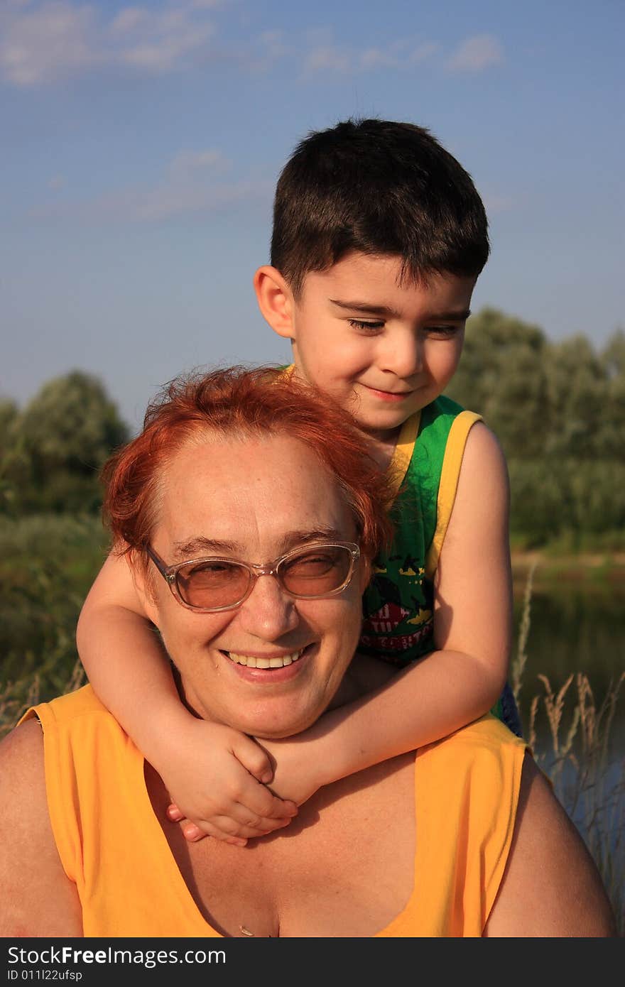 Portrait of an elderly woman with a boy on the bank of the river. Portrait of an elderly woman with a boy on the bank of the river.