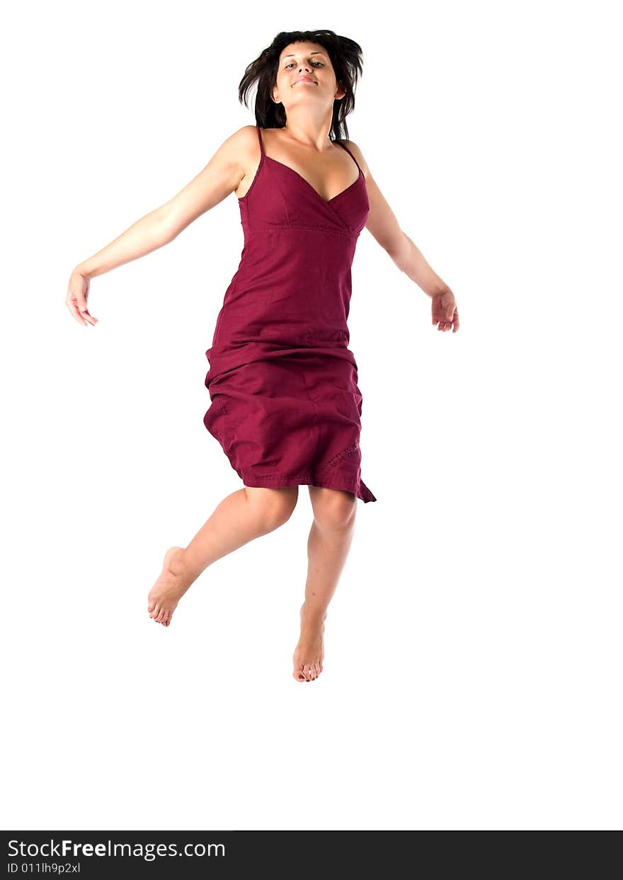 Beautiful young lady in red sun-dress jumping isolated white. Beautiful young lady in red sun-dress jumping isolated white