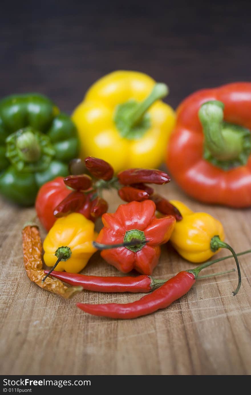 Some fresh paprikas on a wooden board. Some fresh paprikas on a wooden board