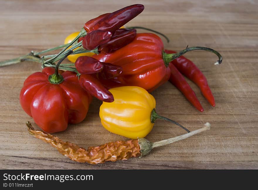 Some fresh paprikas on a wooden board. Some fresh paprikas on a wooden board