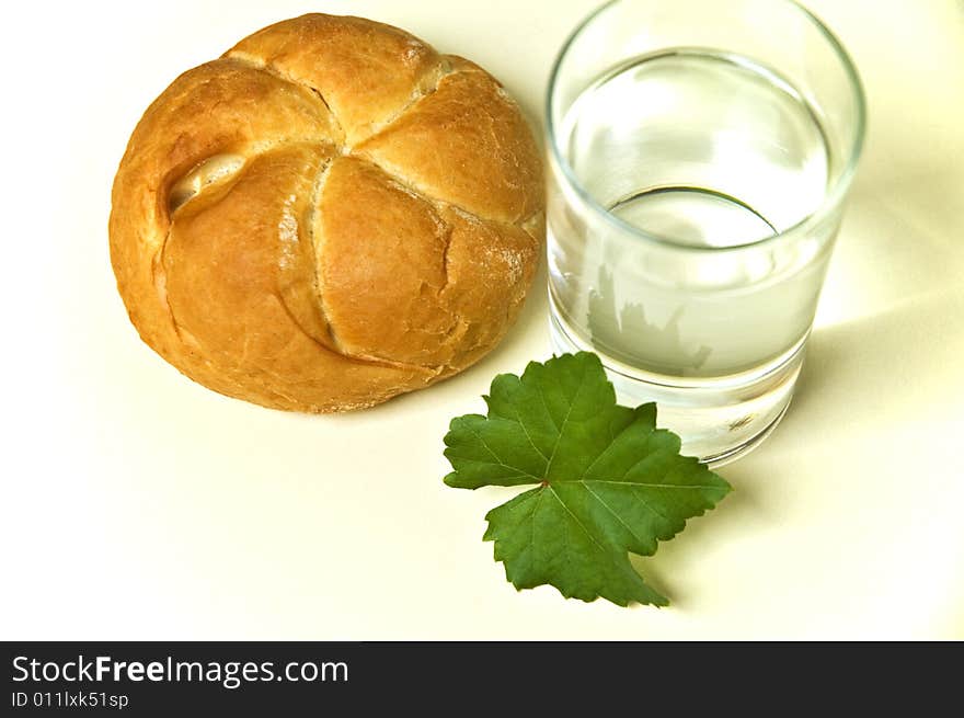 Bread roll and glass of water. Bread roll and glass of water.